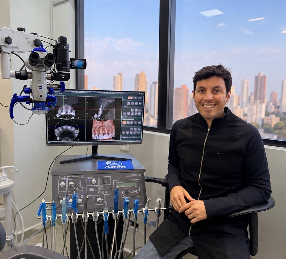 Dr. Pablo Amoroso no consultório, ao lado do microscópio operatório